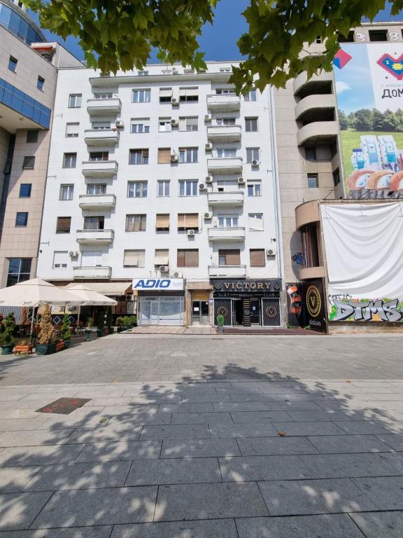 een groot wit gebouw met een straat ervoor bij Downtown Belgrade Hostel and Apartments in Belgrado