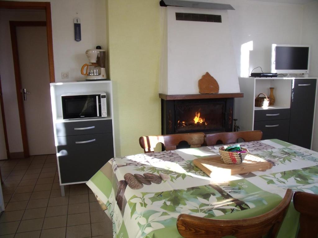 a dining room with a table and a fireplace at Gîte Les Hirondelles in Plombières-les-Bains