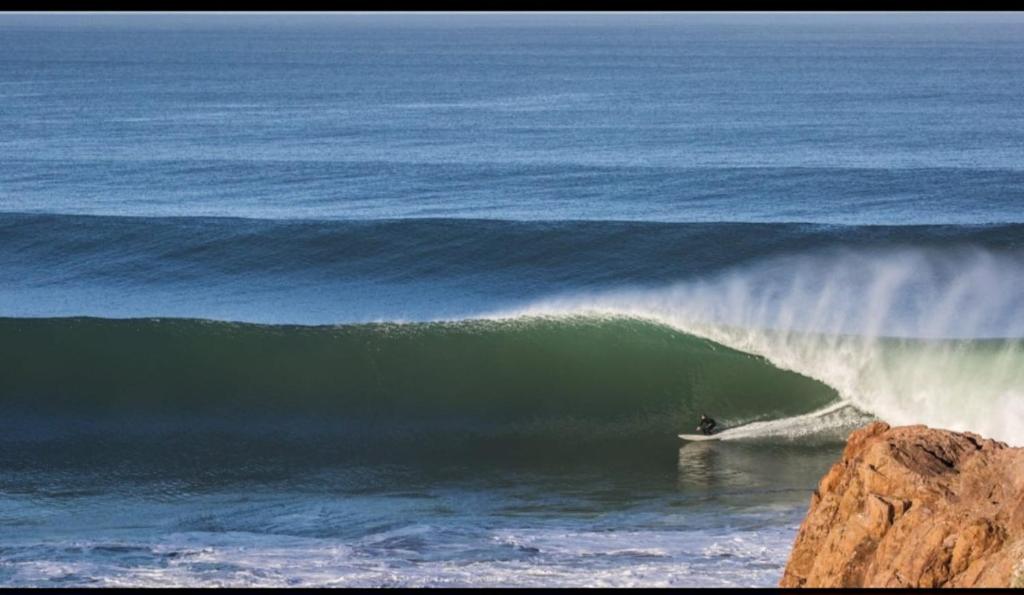 a person riding a wave on a surfboard in the ocean at Dar diafa samira in Mirleft