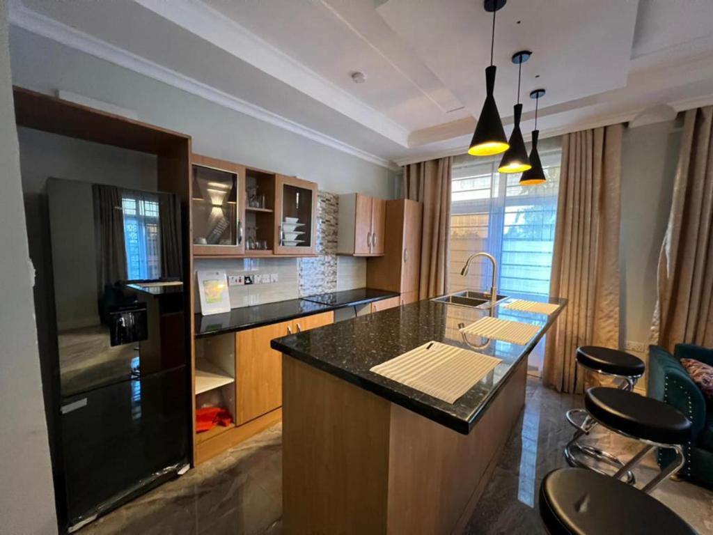 a kitchen with a counter and a island in it at Remarkable 2-Bed Apartment Dar el Salam Tanzania in Dar es Salaam