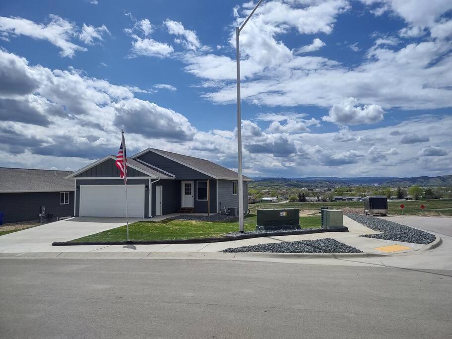 une maison arborant un drapeau en face d'une rue dans l'établissement Dakota Ridge, à Rapid City