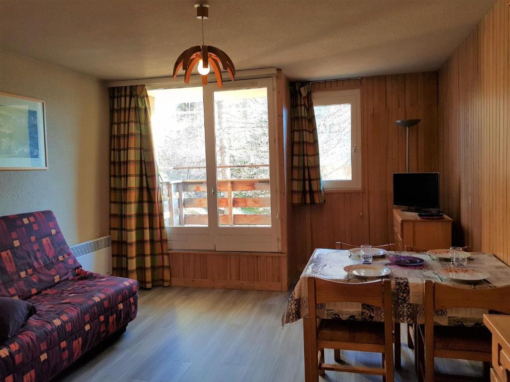 a living room with a table and a couch at Studio Orcières Merlette, 1 pièce, 4 personnes - FR-1-636-98 in Orcières