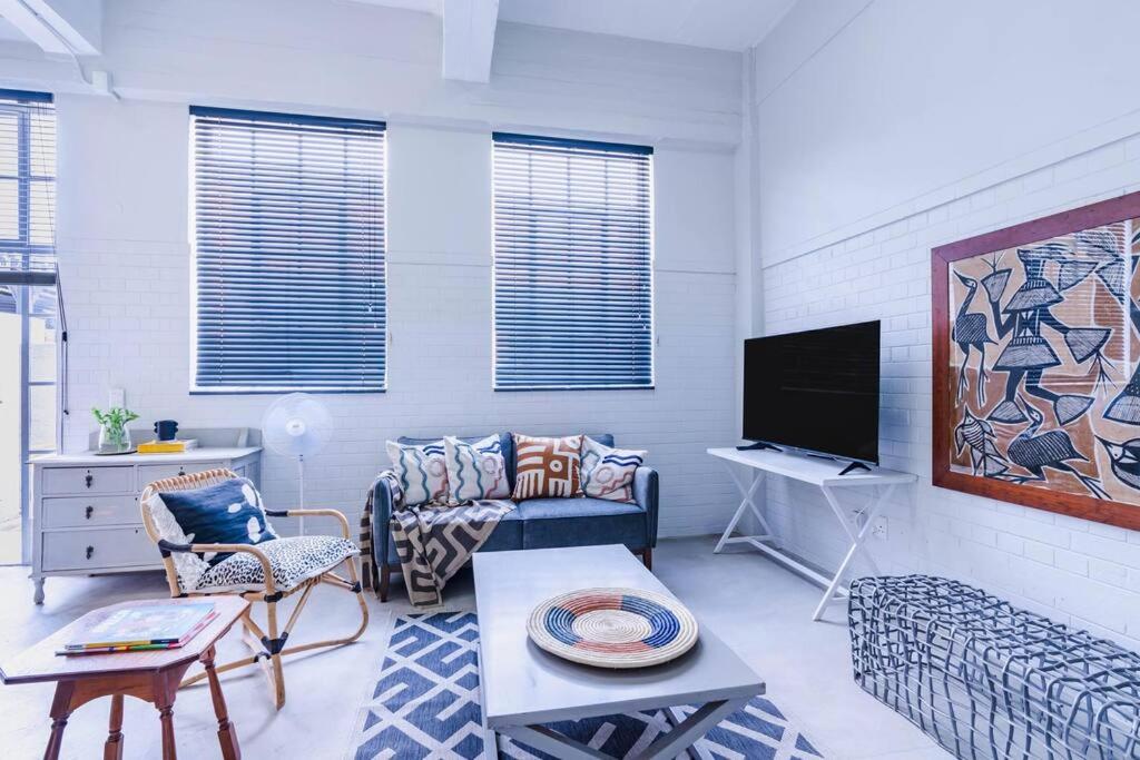 a living room with a couch and a tv at Modern 1 bedroom apartment in Braamfontein Werf in Johannesburg