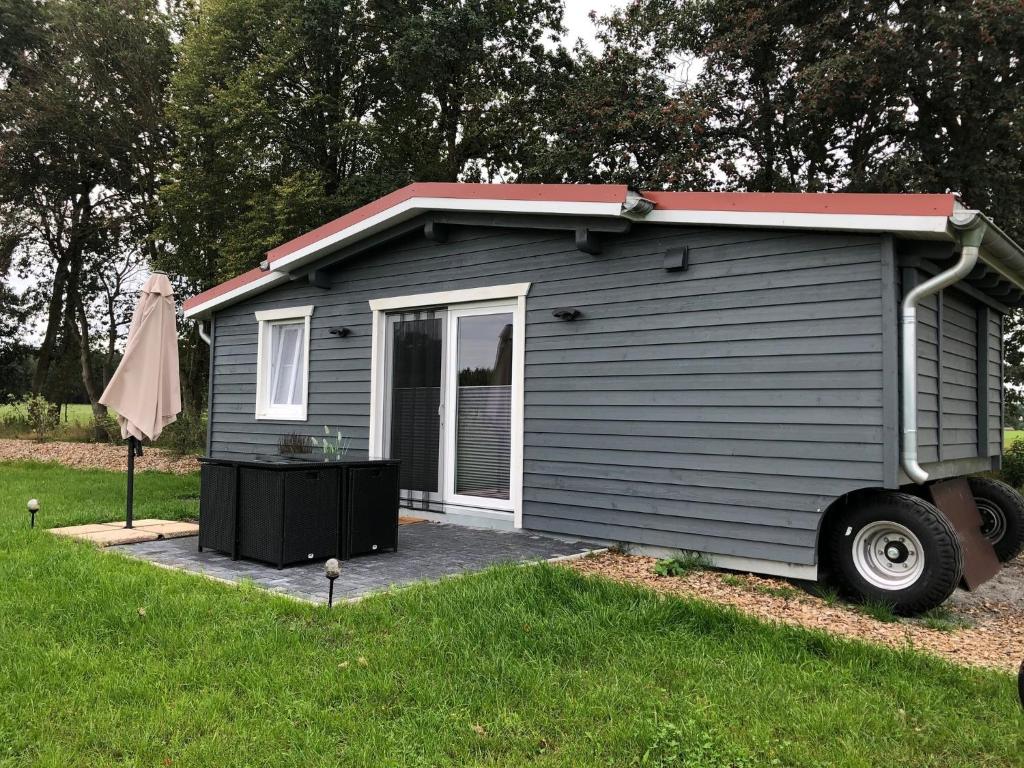 a gray tiny house with a red roof at HeiDeluxe TinyHouse in Soltau