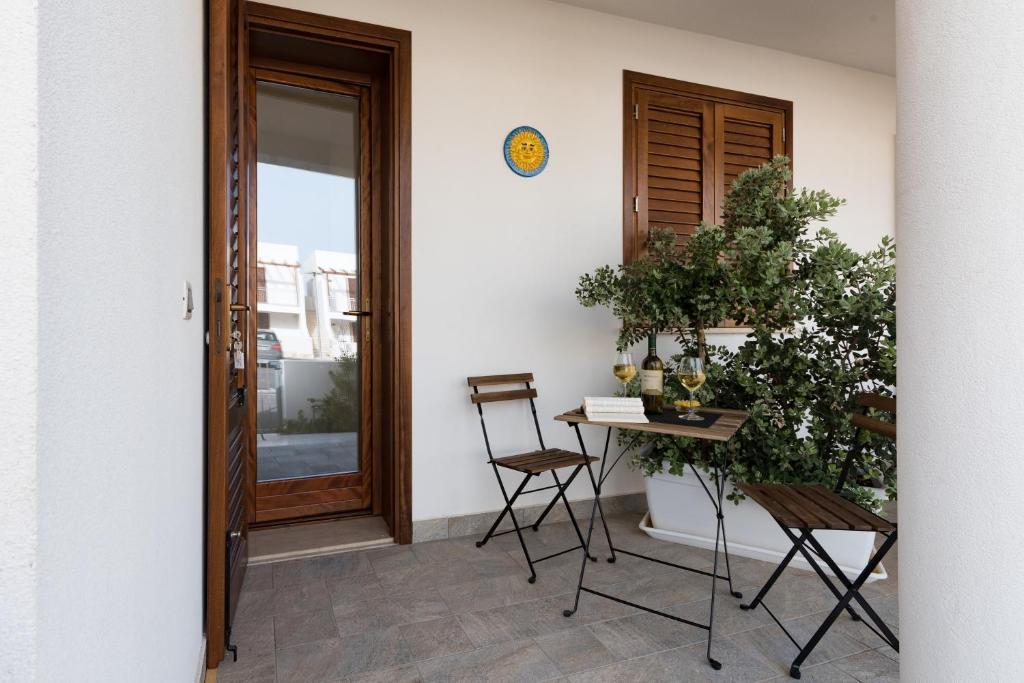 a room with a table and chairs next to a door at I Tre Golfi - Via Salvatore Quasimodo in San Vito lo Capo