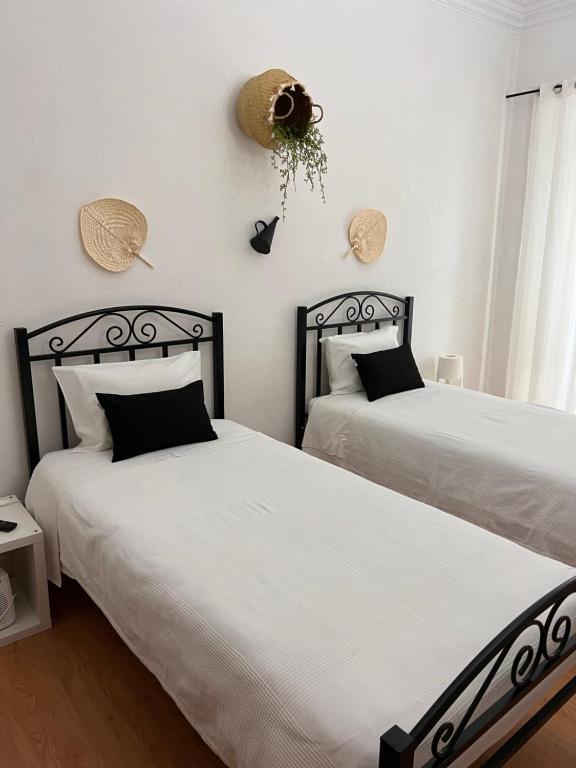 two beds sitting next to each other in a bedroom at Avis Guesthouse in Évora