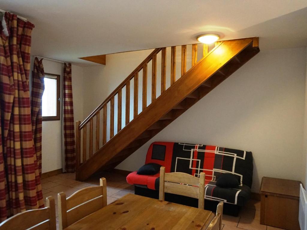 un salon avec une table et un escalier dans l'établissement Duplex cosy 60 m², 7-8 pers, proche pistes et commerces, parking inclus, animaux acceptés. - FR-1-636-6, à Orcières