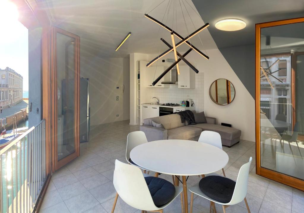 ein Wohnzimmer mit einem weißen Tisch und Stühlen in der Unterkunft Serendipity apartment in Venedig