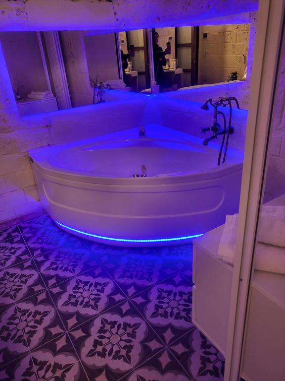a bathroom with a tub with blue lights in it at QUART0 GREC0 Suite 17 in Altamura