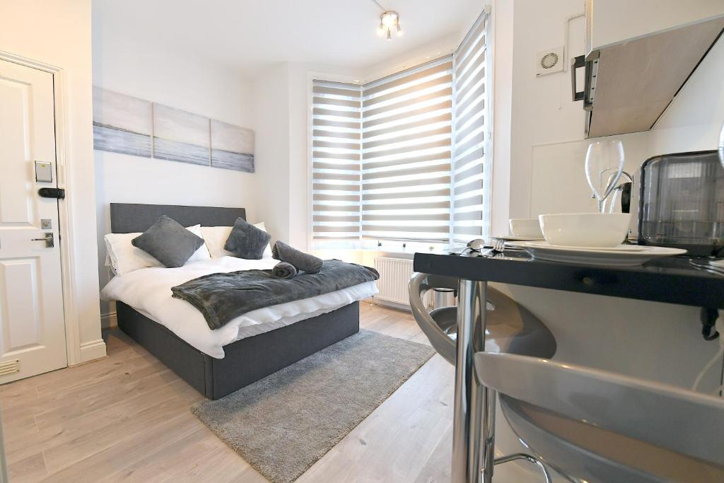 um quarto com uma cama e uma secretária num quarto em Central London Luxury Studios Fulham Close to Underground Newly Refurbished em Londres