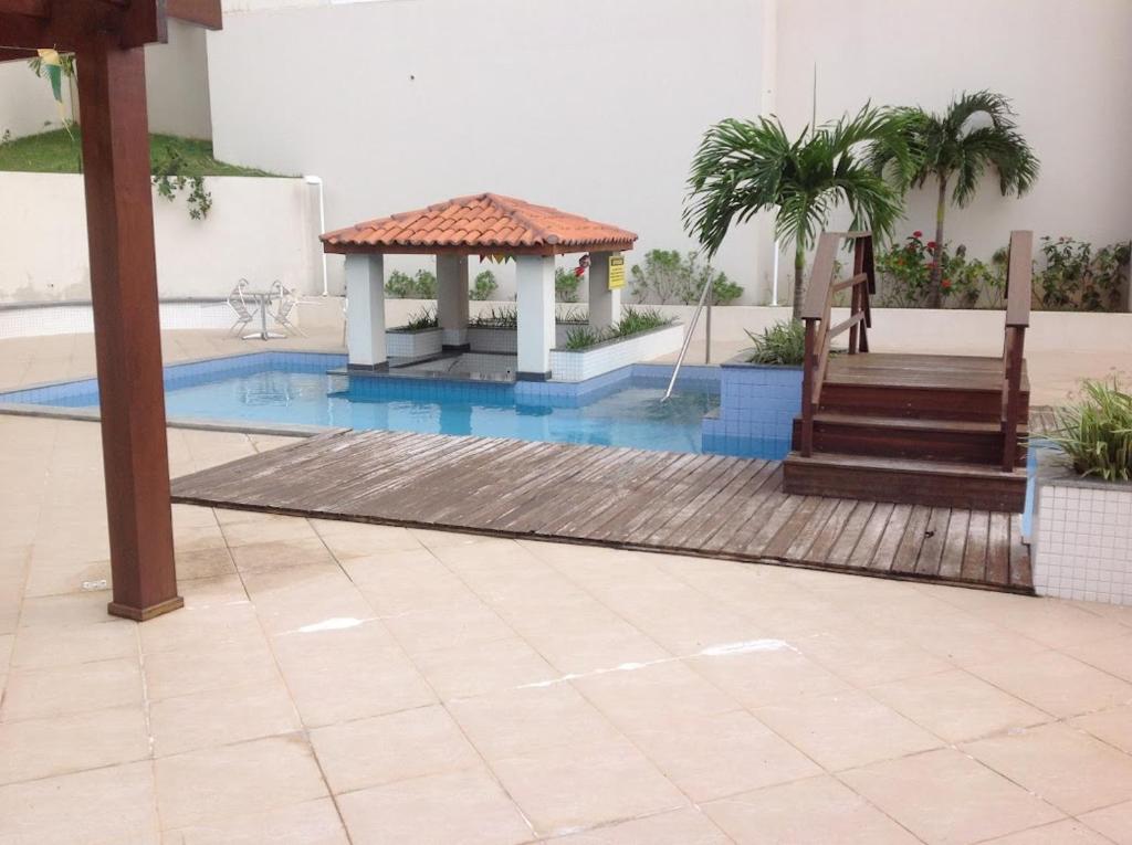 a swimming pool with a gazebo in a building at Apartamento fino e decorado. in Lauro de Freitas