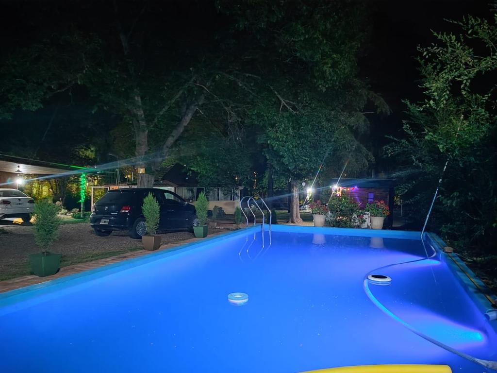 ein blauer Pool in einem Hof bei Nacht in der Unterkunft Casa del arroyo in Villa General Belgrano