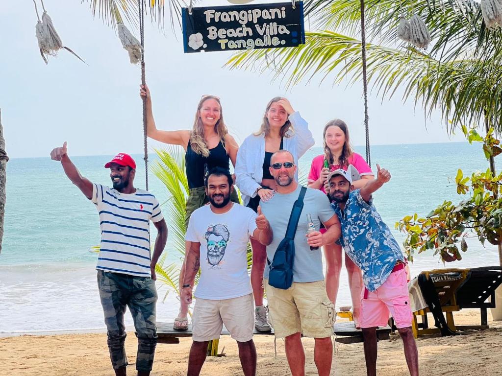 a group of people standing on the beach at Frangipani Beach Villa in Tangalle