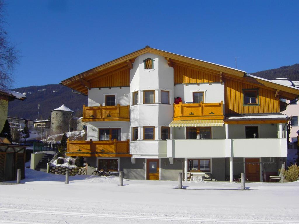 a building with a wooden roof in the snow at Appartement Pichler in Radstadt