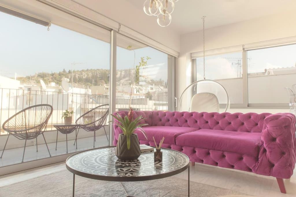 un sofá púrpura en una sala de estar con mesa en Luxury Apartment near Acropolis-Living Stone Gold, en Atenas