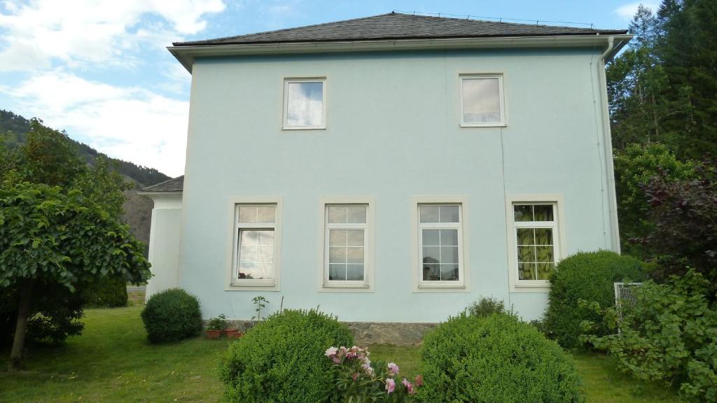 a white house with bushes in front of it at Lemmerer Homestay in Sankt Lorenzen bei Knittelfeld