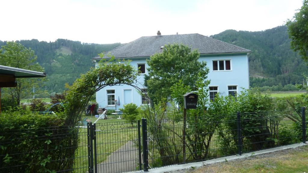 una casa blanca con una valla delante en Lemmerer Homestay en Sankt Lorenzen bei Knittelfeld