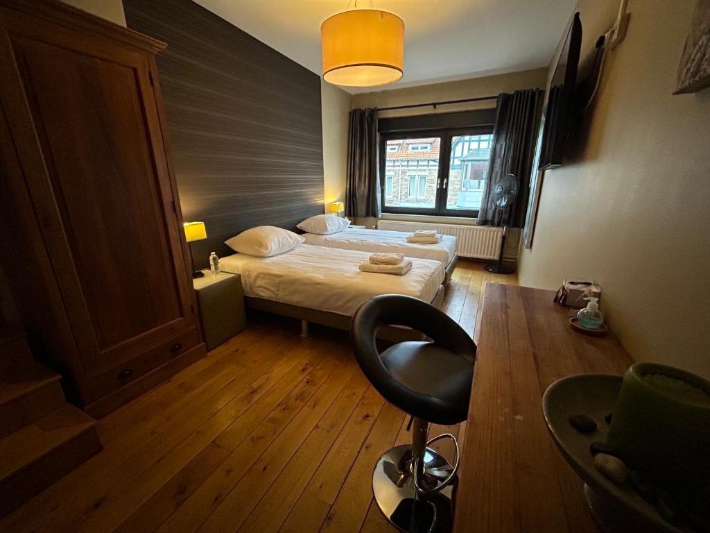 フランコルシャンにあるRace & Roomsのベッドと椅子が備わる小さな客室です。