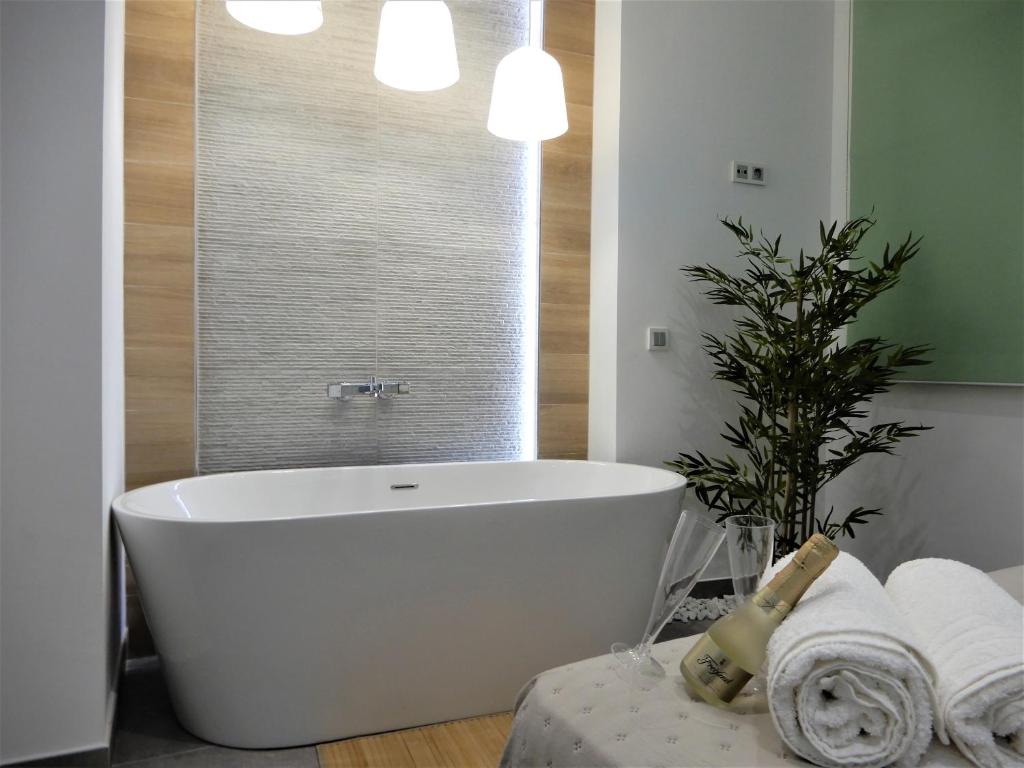 een wit bad in een badkamer met een plant bij Romántico estudio centro de Algeciras in Algeciras