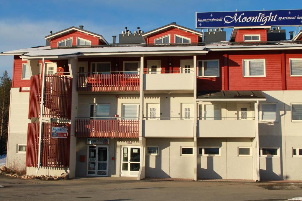 un immeuble d'appartements rouge et blanc dans l'établissement Polar Star Moonlight Apartments, à Levi