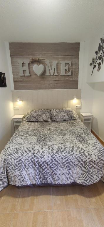 sypialnia z łóżkiem z znakiem serca na ścianie w obiekcie Apartamento Estudio Ruymar Jupiter w mieście Benalmádena