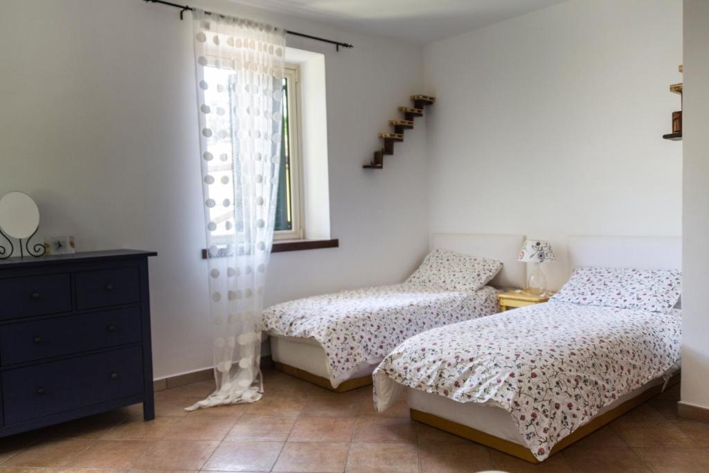 sypialnia z dwoma łóżkami i oknem w obiekcie Casa Tronola w mieście Laceno