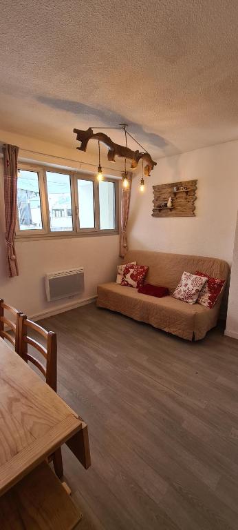 a large living room with a bed and a table at Appartement chaleureux, Gourette Pieds des pistes in Gourette