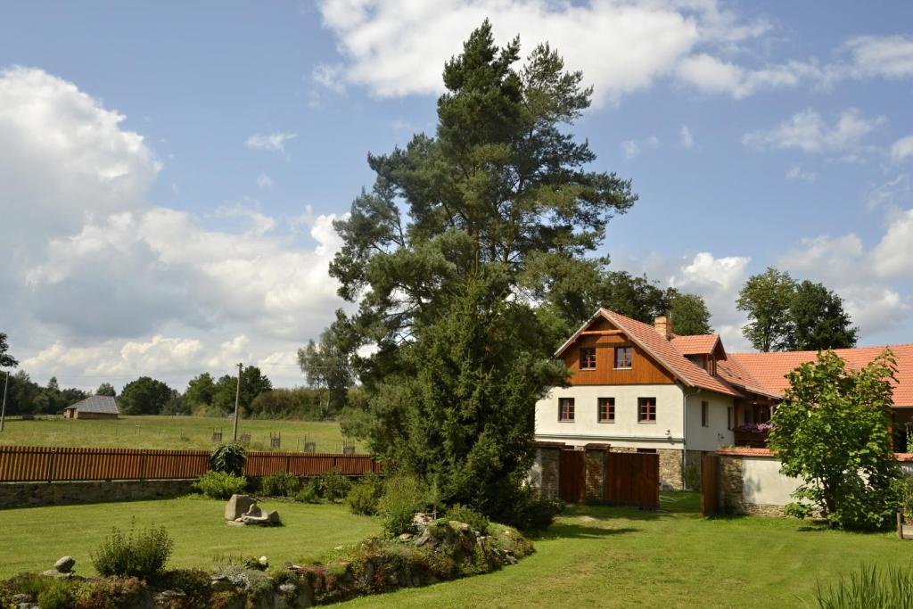 ein weißes Haus mit einem Baum im Hof in der Unterkunft Jonášův Mlýn in Zhoř u Mladé Vožice