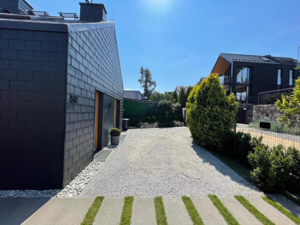 a garden with a gravel driveway next to a house at Grafit in Mechelinki