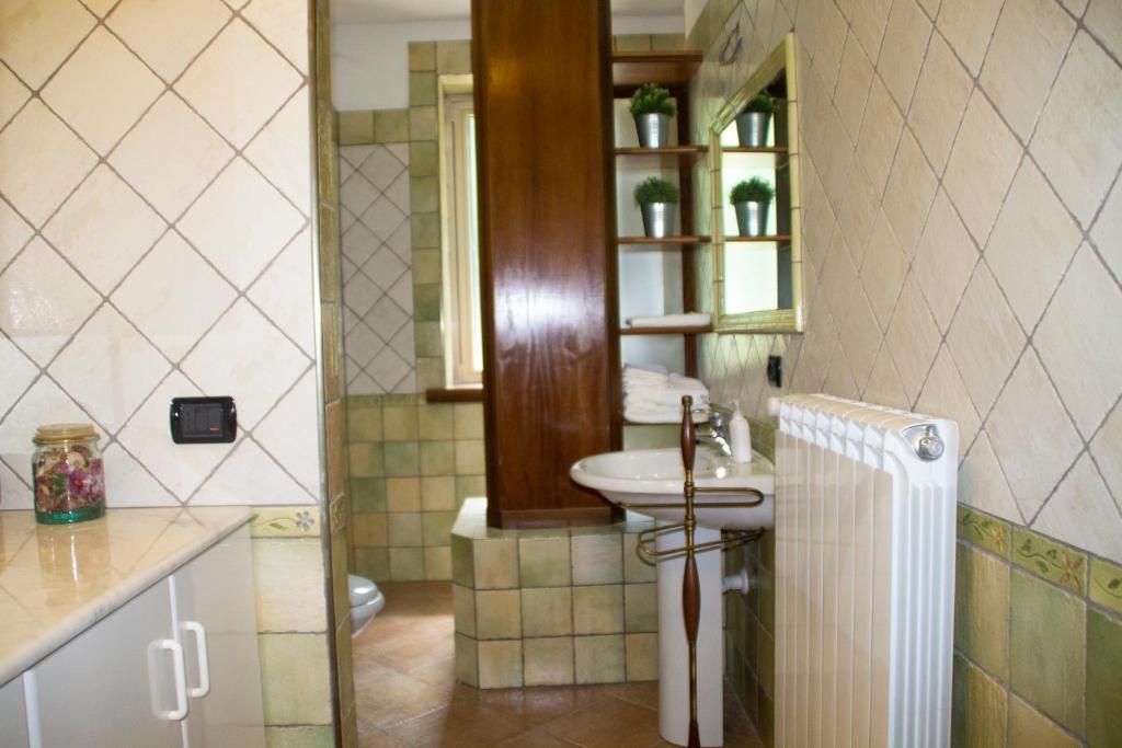 łazienka z umywalką, toaletą i lustrem w obiekcie Casa Tronola w mieście Laceno