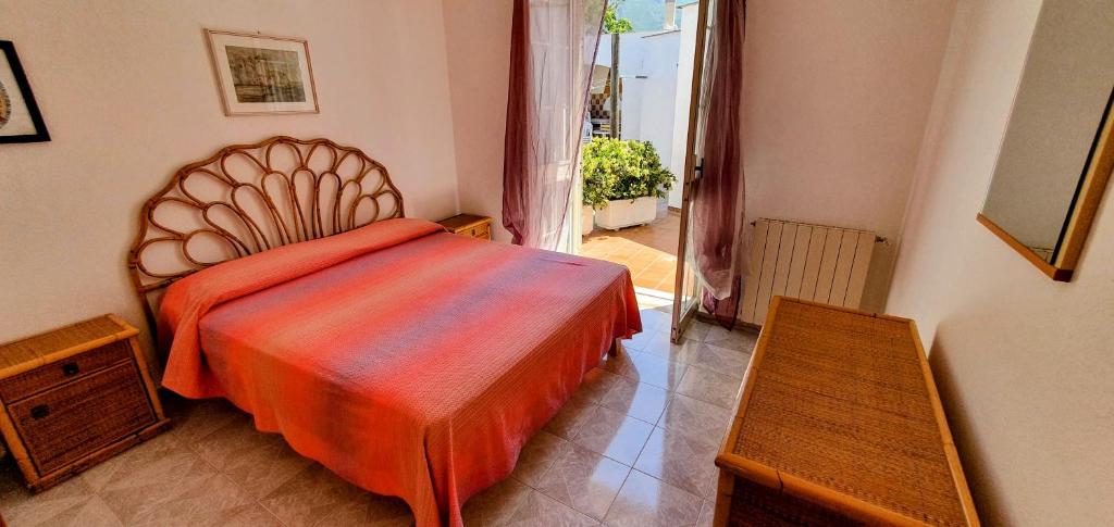 een slaapkamer met een bed met een oranje dekbed bij Appartamenti Luongo in Ischia