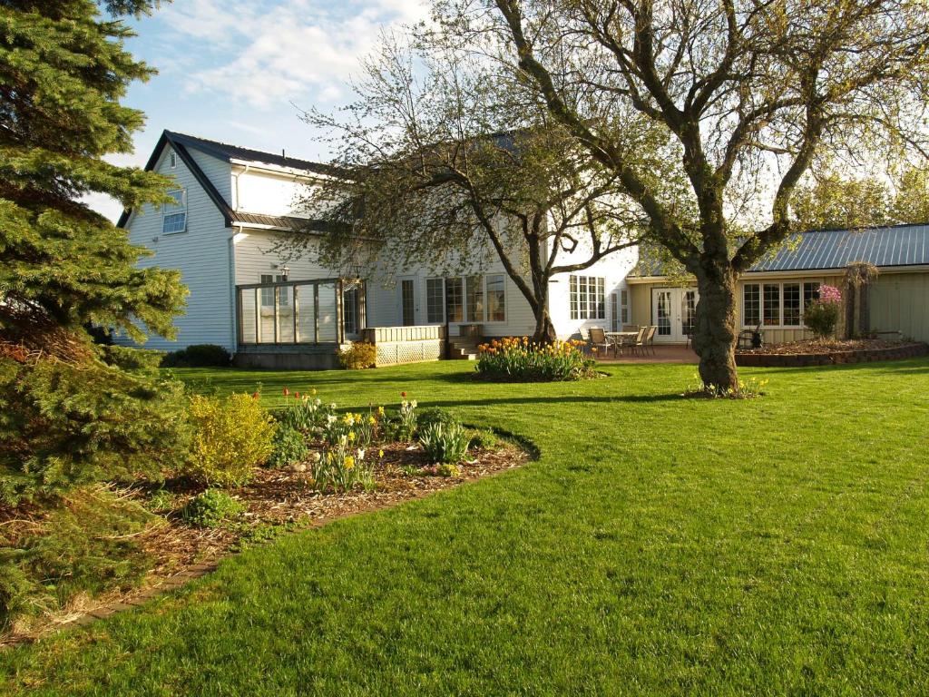 a white house with a tree and a yard at Bakers Chest B&B in Truro