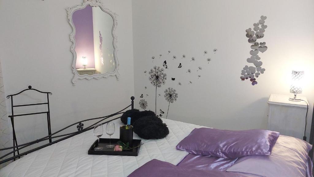 sypialnia z łóżkiem z fioletową pościelą i lustrem w obiekcie La Terrazza suite stile retrò, 90 mq con doccia sauna Wi-Fi terrazzo e garage w Trydencie