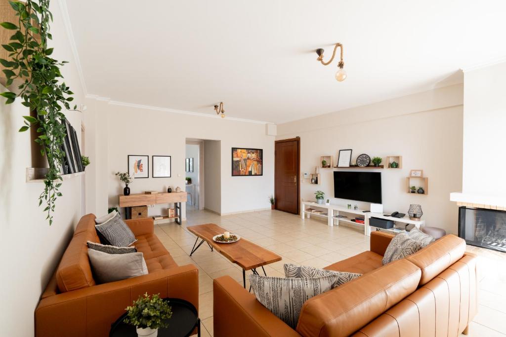 a living room with couches and a tv at Athens Airport Loft in Spata