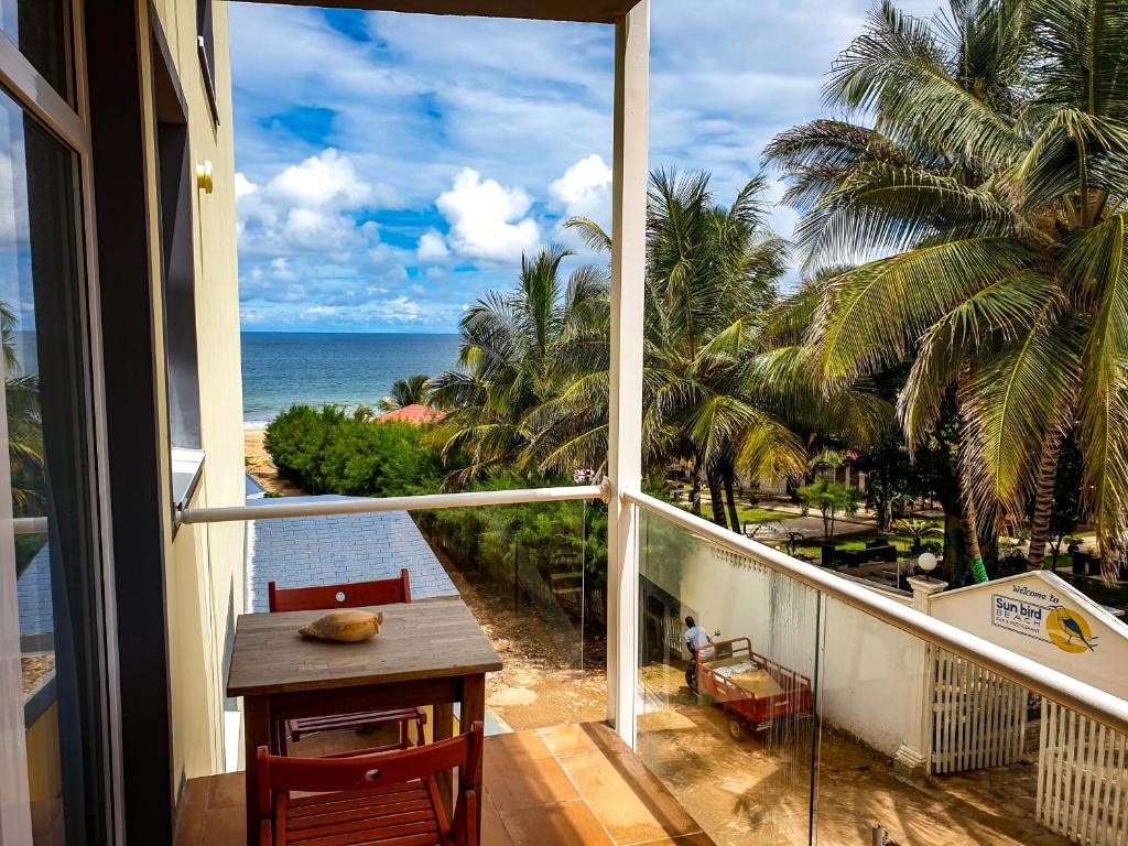 a balcony with a table and a view of the ocean at Kasumai Beach Resort in Bijilo