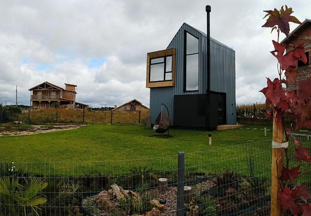a small house on a yard with a fence at Tiny House Cambará in Cambará
