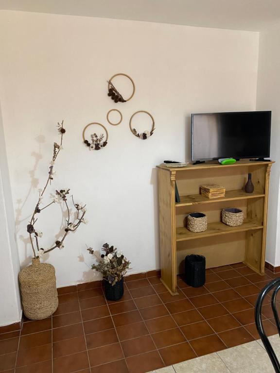 uma sala de estar com televisão e piso em azulejo em Pacífico Il em Córdova