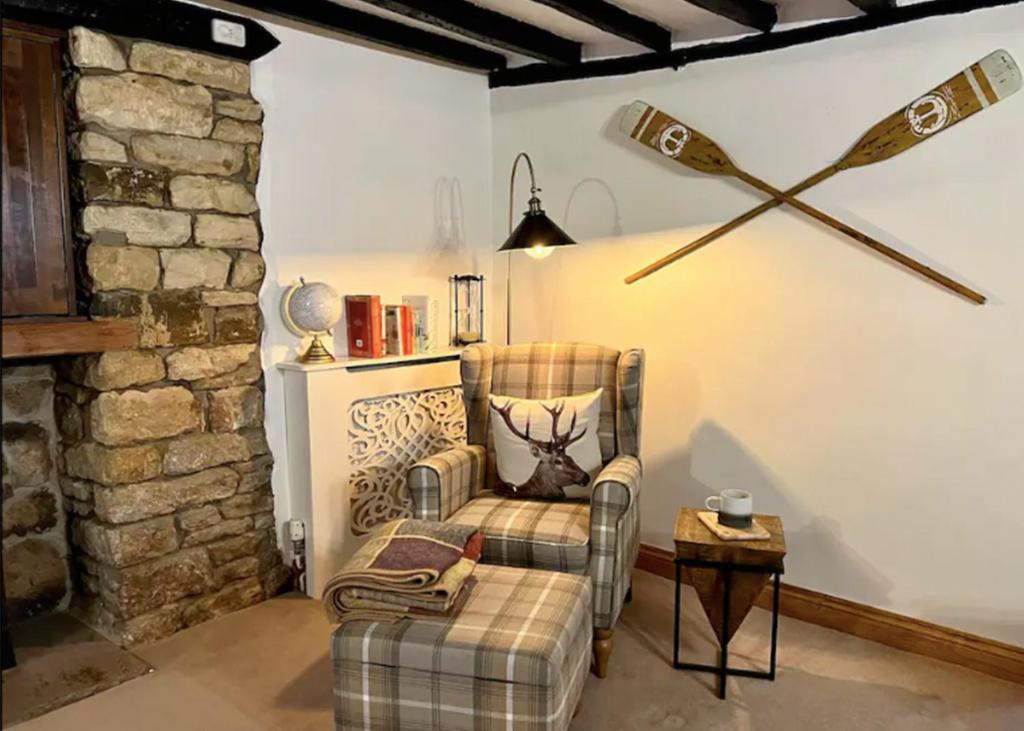 a living room with a chair and a table at China Cottage - Quaint, Cosy, Cotswolds Retreat in Charlbury