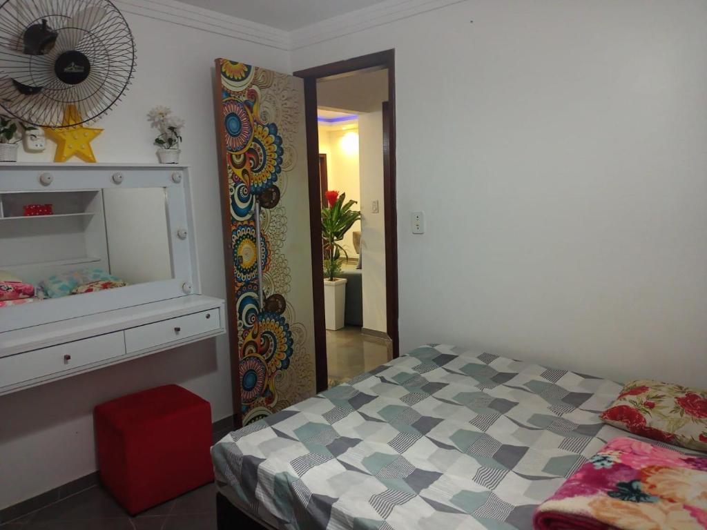 a small bedroom with a bed and a mirror at Casa em Condomínio, Piscina Privativa e Área Gourmet in Camaçari