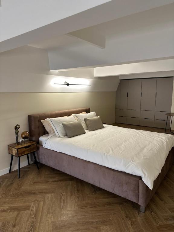 ein Schlafzimmer mit einem großen Bett mit weißer Bettwäsche in der Unterkunft Old Slabada Loft Kaunas in Kaunas