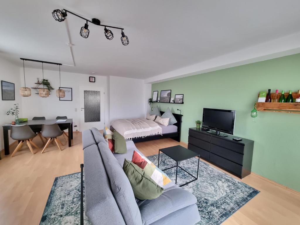 a living room with a couch and a dining room at Ferienwohnung Appartement Bad Bergzabern mit Schwimmbad und Sauna in Bad Bergzabern