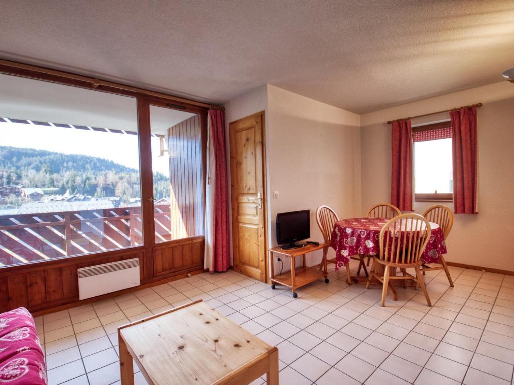 a living room with a table and a balcony at Appartement Morillon 1100, 3 pièces, 6 personnes - FR-1-642-37 in Morillon