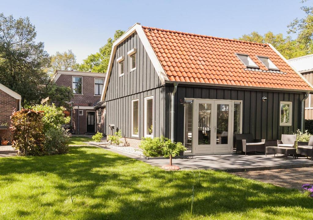 een zwart huis met een oranje dak bij Camping Tante Bob & de Rakkertjes in Schoonoord