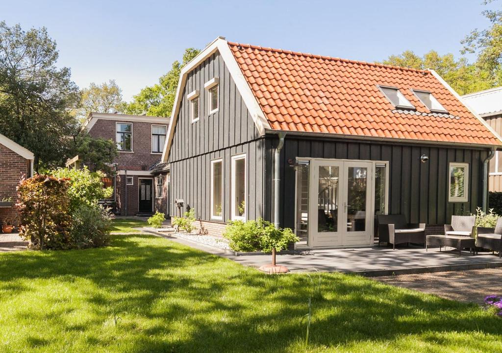 a black house with an orange roof at Camping Tante Bob & de Rakkertjes in Schoonoord