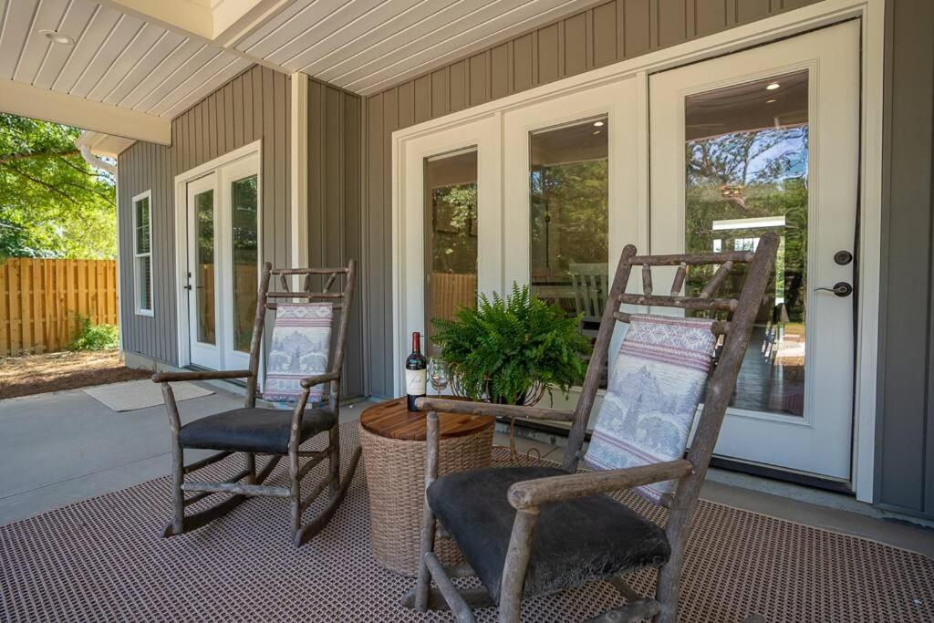 a porch with two chairs and a table with a plant at Relax, Rewind, Repeat - New Country Cottage in High Point