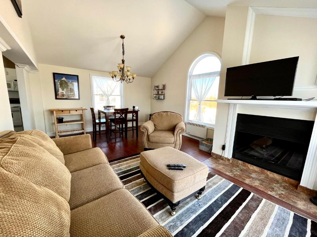 a living room with a couch and a fireplace at Chaleureux condo à Magog in Magog-Orford