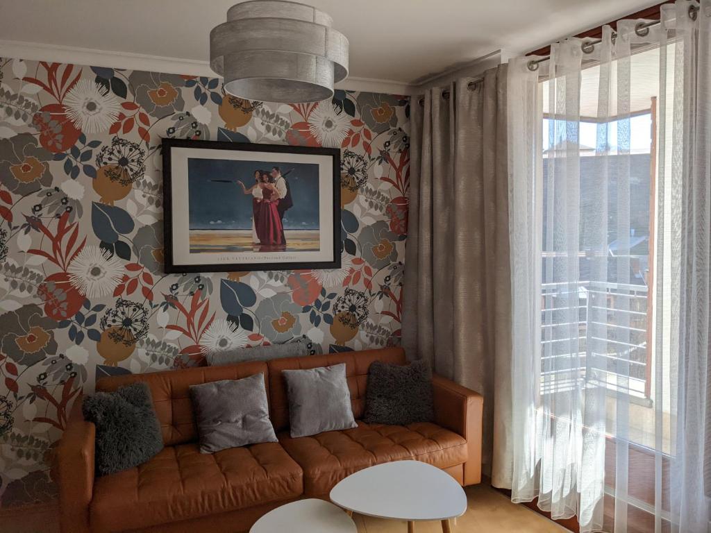 - un salon avec un canapé et une photo sur le mur dans l'établissement Minaret Apartman, à Eger