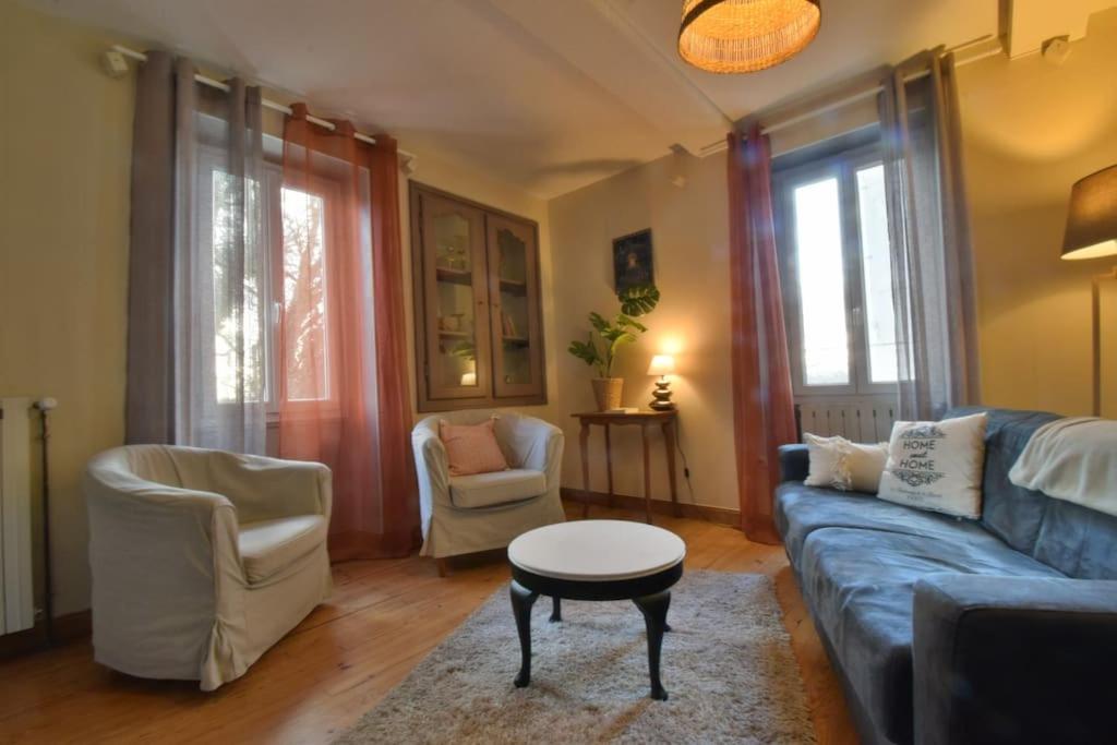 a living room with a blue couch and two chairs at Gite de groupe &quot;L&#39;Unisson&quot; Domaine La Rose des Vents in Castelnau-sur-lʼAuvignon