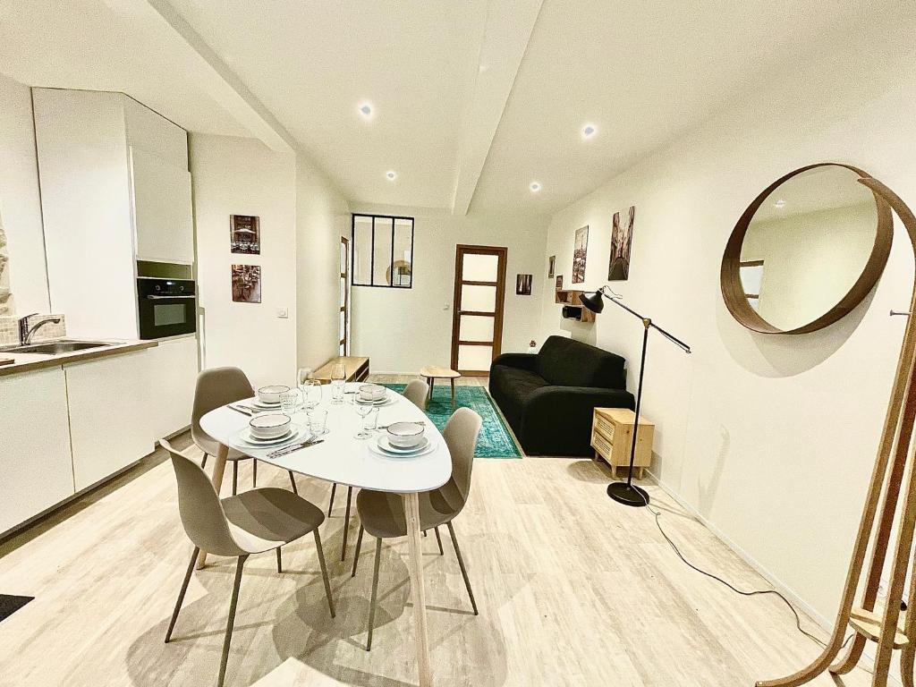 eine Küche und ein Wohnzimmer mit einem weißen Tisch und Stühlen in der Unterkunft Appartment Montorgueil/Châtelet in Paris