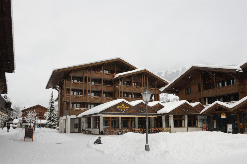 un lodge de ski avec de la neige sur le toit dans l'établissement Hotel Krone Lenk, à Lenk im Simmental